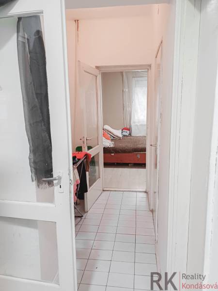 Keskeny fehér folyosó vezet a gyerekszobába egy családi házban.