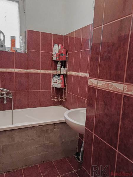 Fürdőszoba zuhanyzóval, piros csempével kirakva, családi házban.