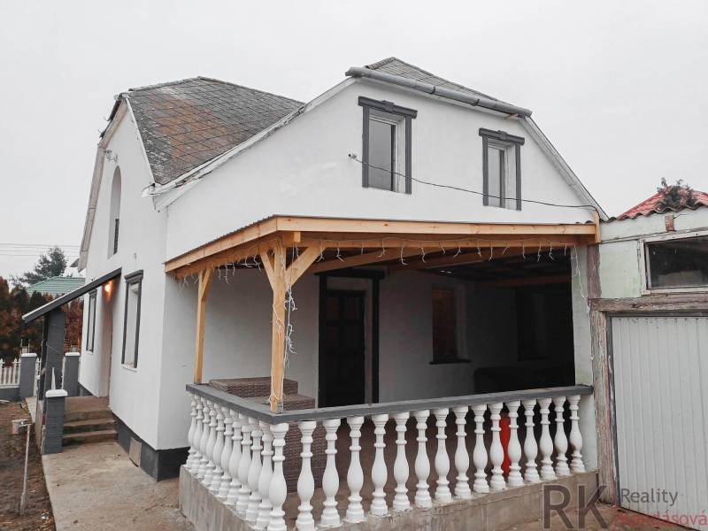 Vizsolyi családi ház terasszal, fehér homlokzattal és fa előtetővel.