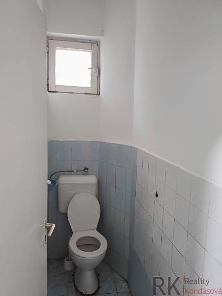 WC egy családi házban kék csempékkel és kis ablakkal.