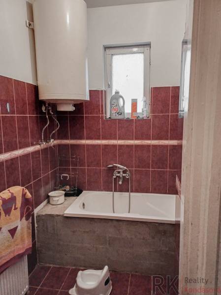 Fürdőszoba családi házban zuhanyzóval, káddal, ablakkal és bojlerrel.