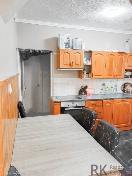 Konyha családi házban fa szekrényekkel és mennyezeti burkolattal.