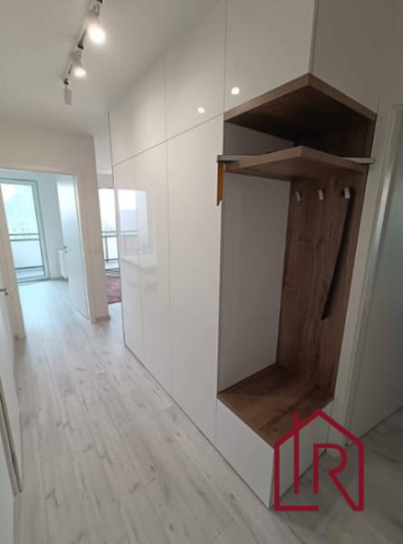 Folyosó egy 3 szobás lakásban fehér szekrényekkel és beépített gardróbbal fa dekorációval.