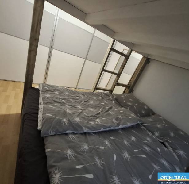 Hálószoba egy kétszobás lakásban fa dekor padlóval és emeletes ággyal.