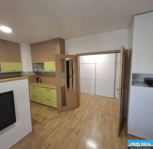 2 szobás lakás belső tere fa mintázatú padlóval és világos bútorokkal.