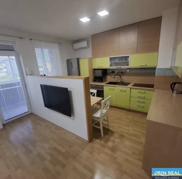 Konyha egy kétszobás lakásban fa dekor padlóval és világos konyhabútorral.