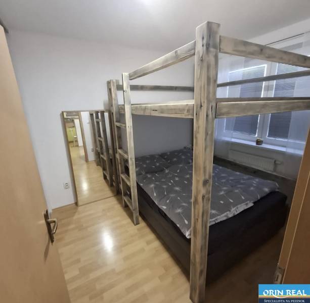 Kétszobás lakásban lévő fa emeletes ágy fa dekoros padlóval.