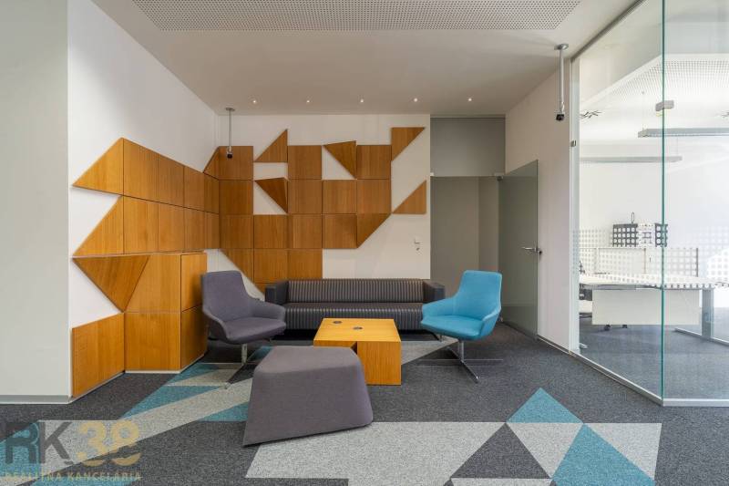 Irodabelső színes ülőhelyekkel, üveggel és geometrikus fa panelekkel.