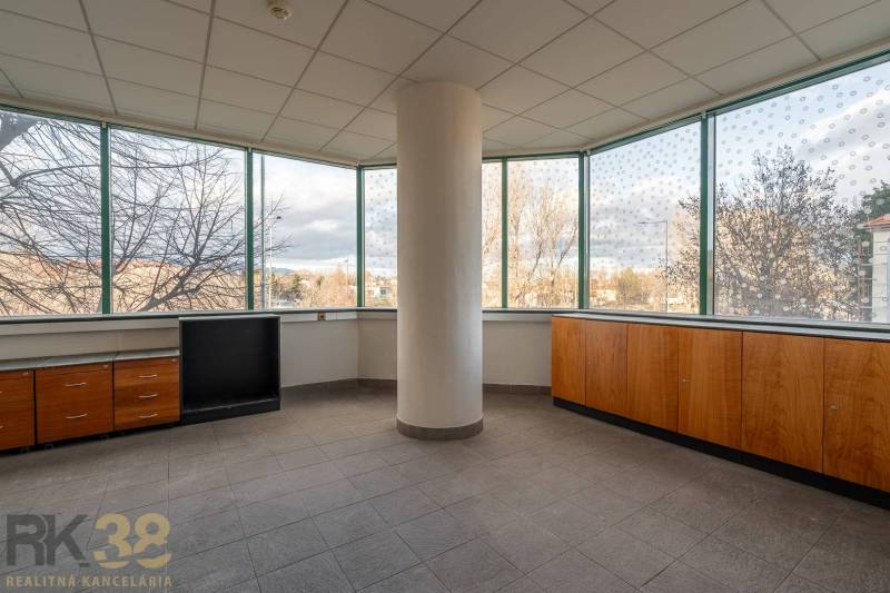 Priestranné kancelárie s veľkými oknami a výhľadom na mesto, podlaha dlaždicová.