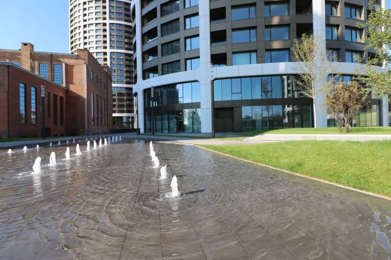 Szökőkút és modern épületek téglás építészettel Pozsonyban - Óváros, a Továrenská utcában.