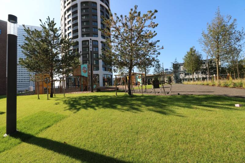 Játszótérrel rendelkező park és toronyház a Pozsony-Óváros Továrenská utcáján.