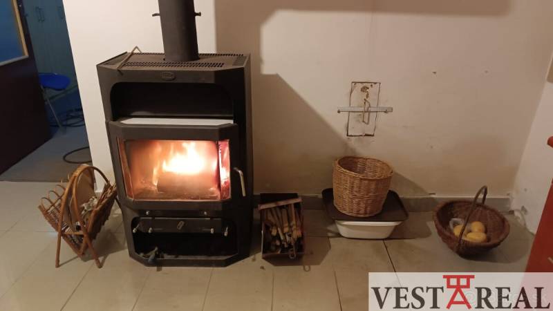 Családi ház kandallóval, fonott kosarakkal és tűzrakó hellyel a meleg és a hangulat fenntartására.