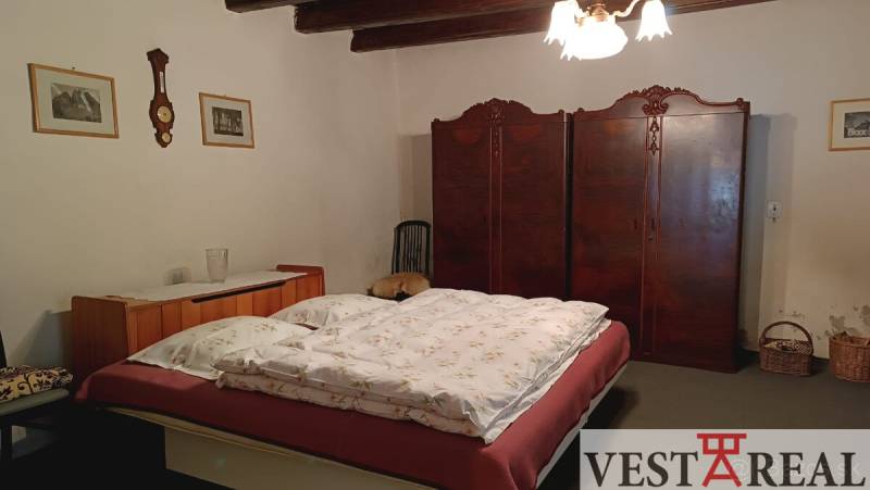 Hálószoba családi házban ággyal, beépített szekrénnyel és vidéki dekorációval.