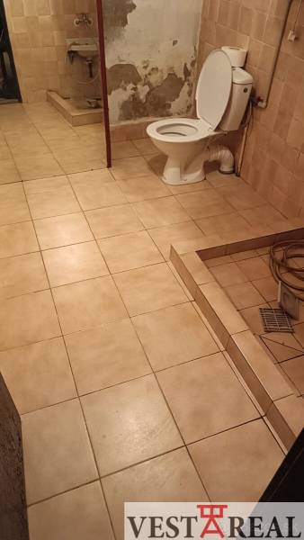 Fürdőszoba családi házban csempékkel és WC-vel, egyszerű és takarékos kialakítás.