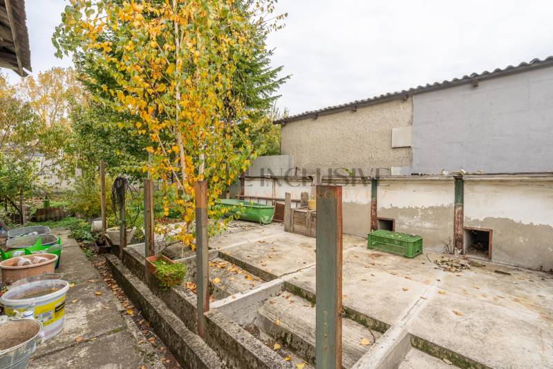 Őszi kert egy családi ház mellett Nagydobronyban, színes falevelekkel a fákon.