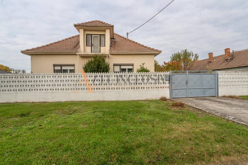 Családi ház Nagydobronyban kerítéssel és gondozott kerttel.