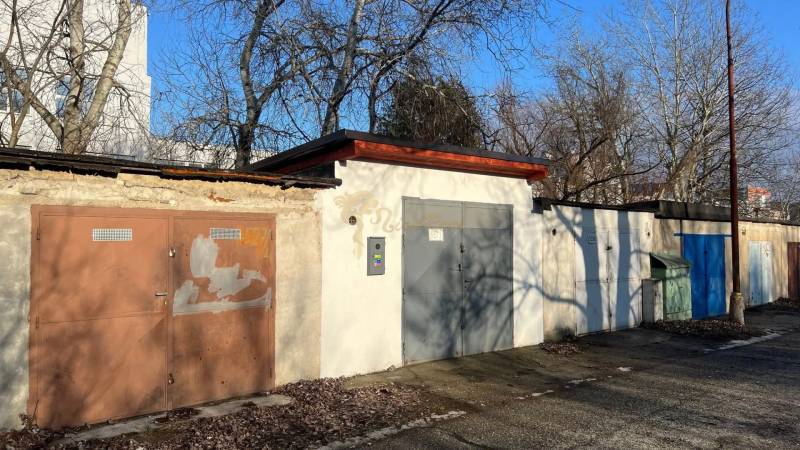 Színes garázsok az Agátová utcában, Pozsony-Dúbravkán, fákkal körülvéve.