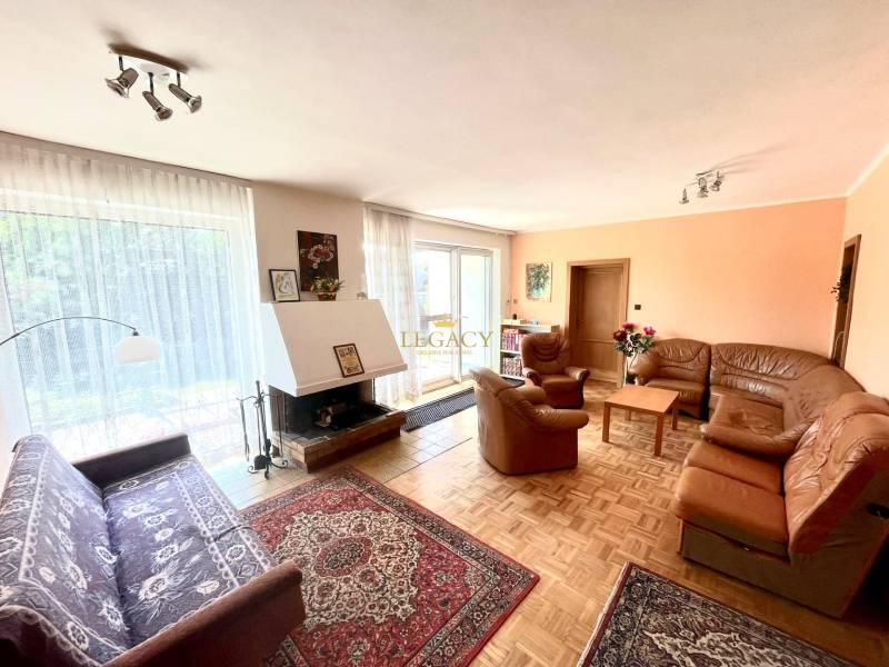 Nappali kandallóval és bőr ülőgarnitúrával egy családi házban.