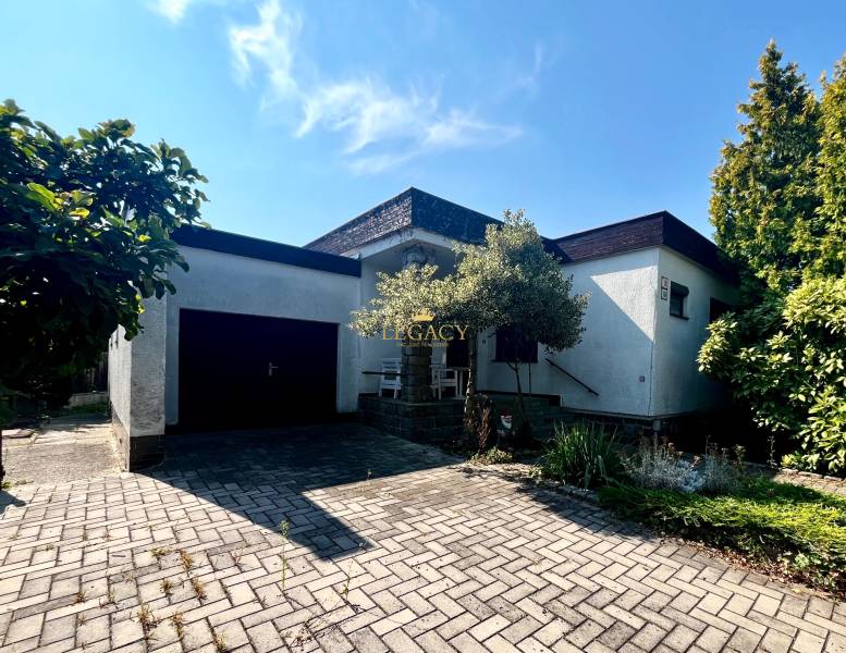 Családi ház Ivanka pri Dunaji-ban garázzsal és virágágyással, a kövezett járdán.