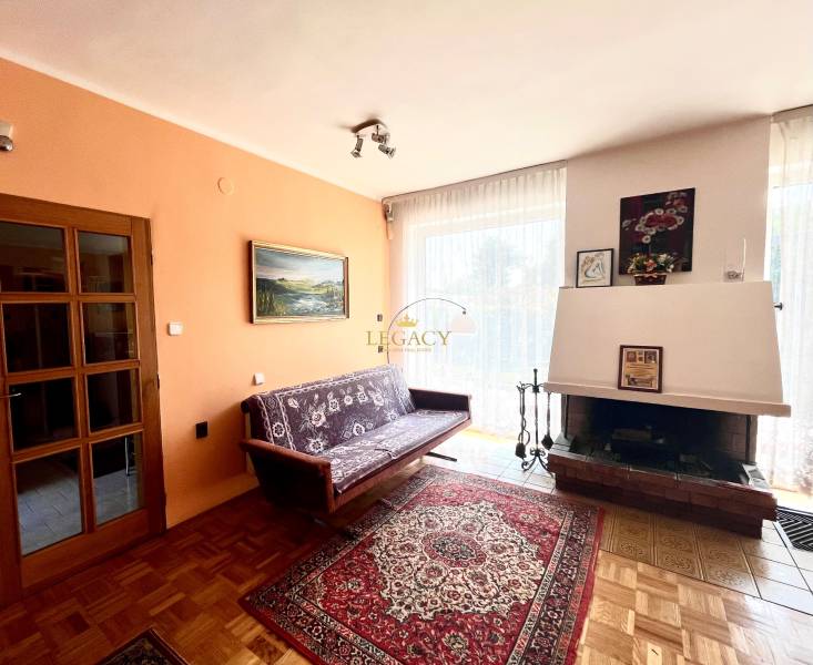 Nappali egy családi házban kandallóval, kanapéval és fa dekorációjú padlóval.