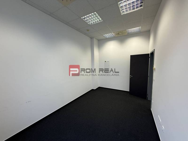 Irodák fehér falakkal és sötét szőnyeggel.