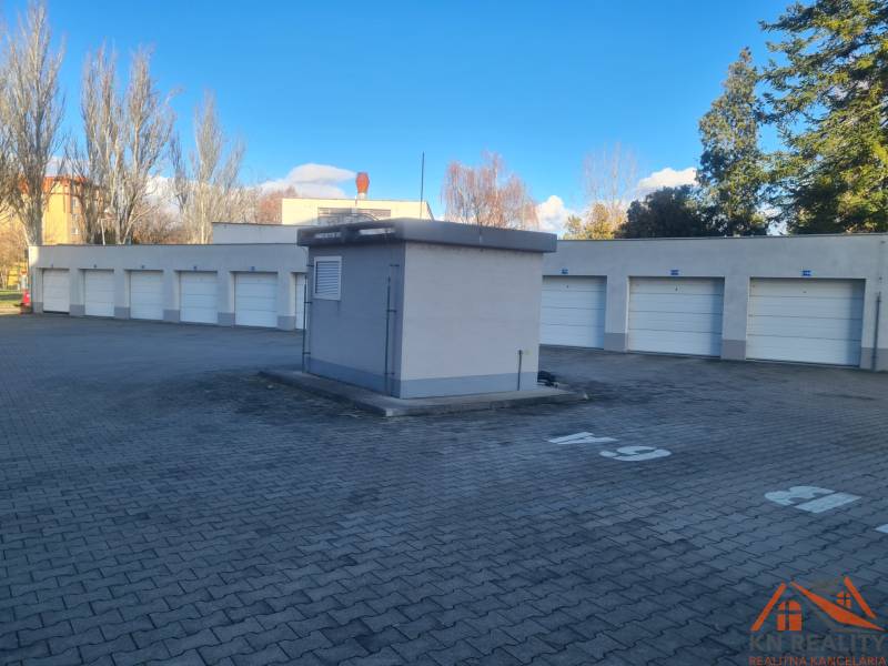 Sorház garázs Komáromban zárt kapukkal, szilárd burkolaton, napsütéses időben.