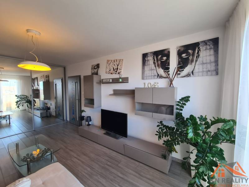 Nappali egy kétszobás lakásban, fa dekoros padlóval és dekoratív elemekkel.