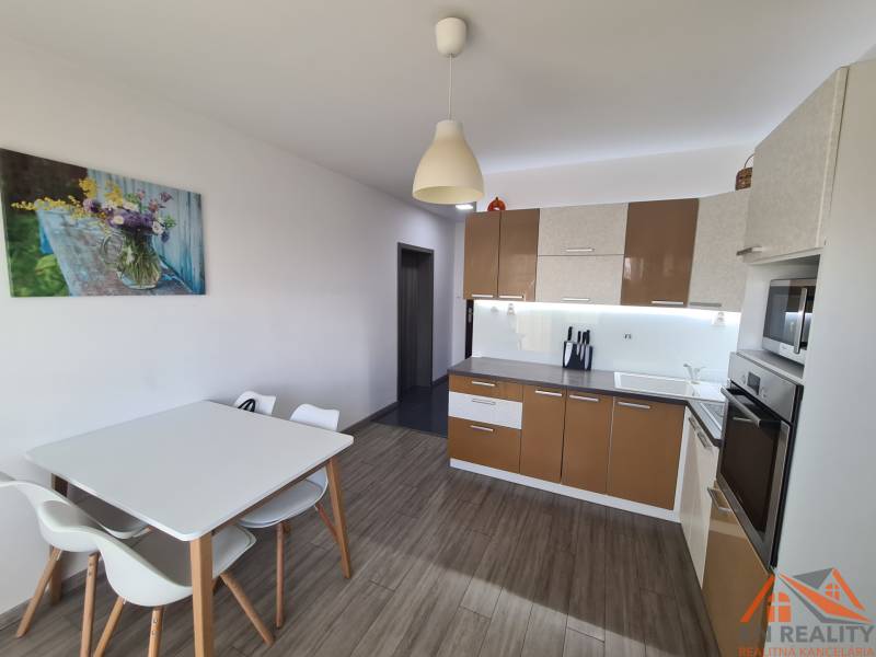 Konyha egy kétszobás lakásban fa dekorációjú padlóval és étkezőasztallal.