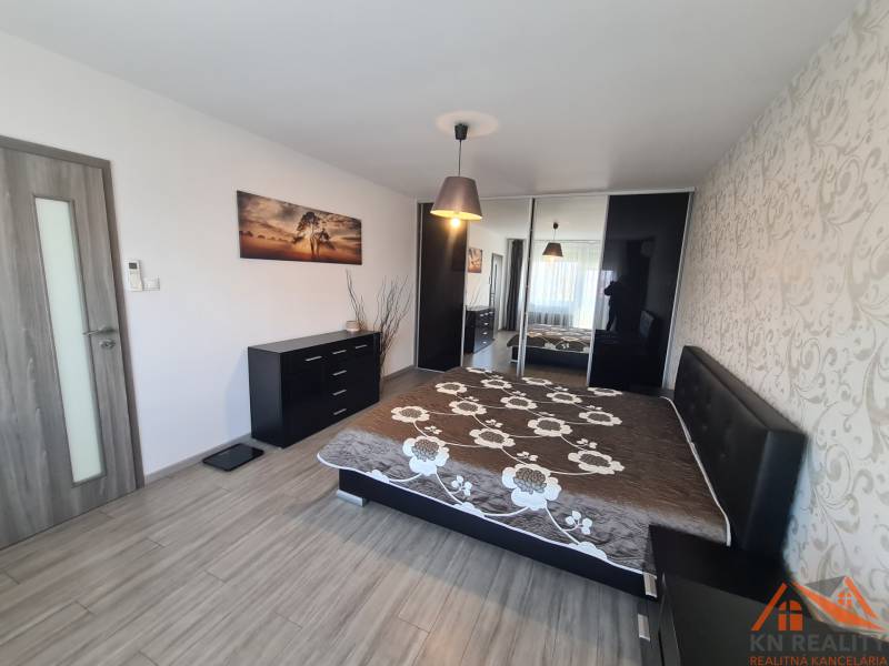 Hálószoba egy kétszobás lakásban, fa dekor padlóval és beépített szekrénnyel.