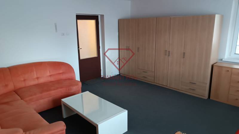 Nappali családi házban kanapéval, asztallal és méretre szabott szekrénnyel.