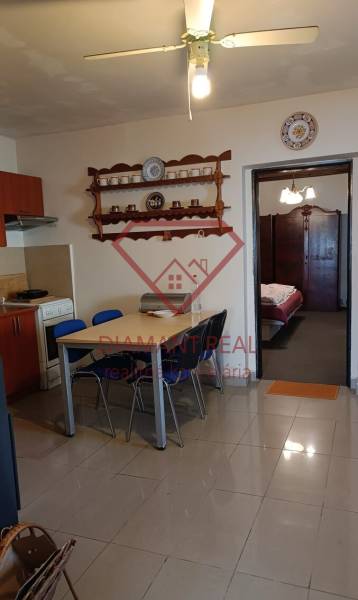 Étkező sarok és konyha családi házban polccal és mennyezeti ventilátorral.