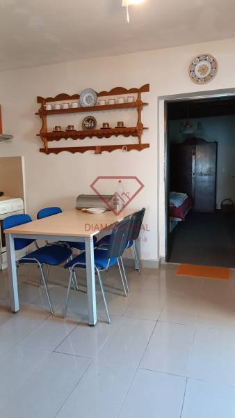 Családi ház étkezője edényeknek szánt polcokkal és asztallal, kék székekkel.