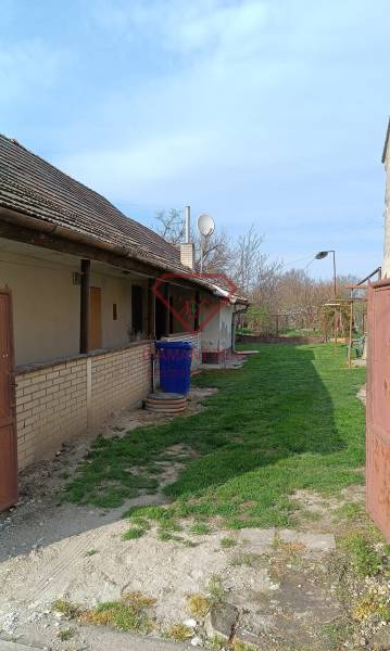 Családi ház a Felsőszeli Salibská utcában gyepes udvarral és bádogkerítéssel.
