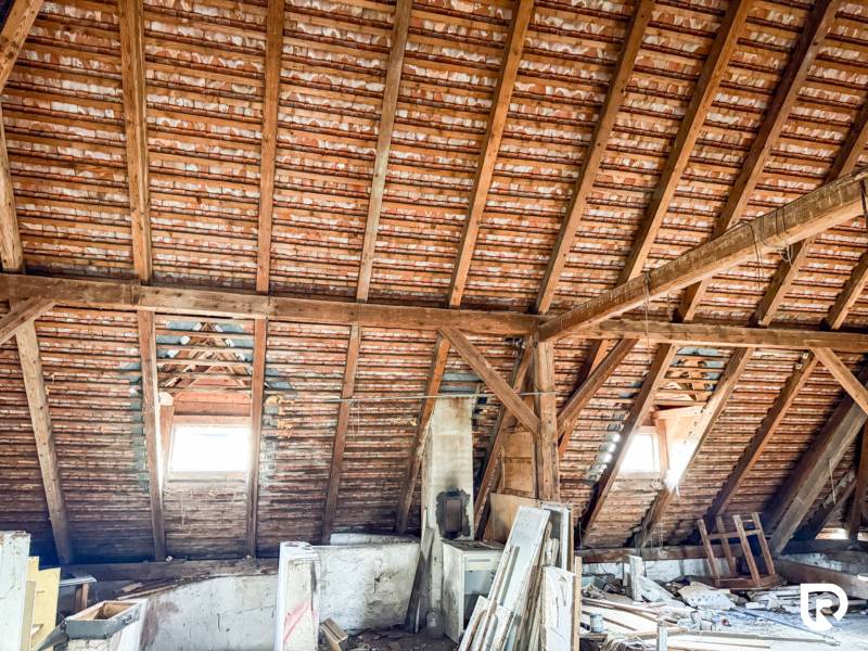 Tetőtér tetőablakokkal és fa gerendákkal családi házban.