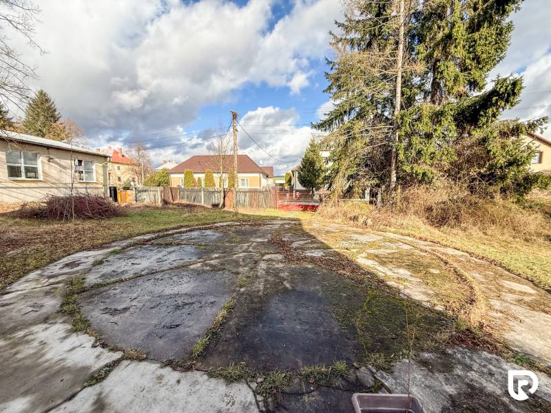 Családi ház Bobot községben, Bobot utcában, betonfelülettel és fákkal a kertben.