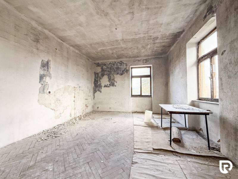 Elhagyatott szoba sérült falakkal és fa dekorációjú padlóval egy családi házban.