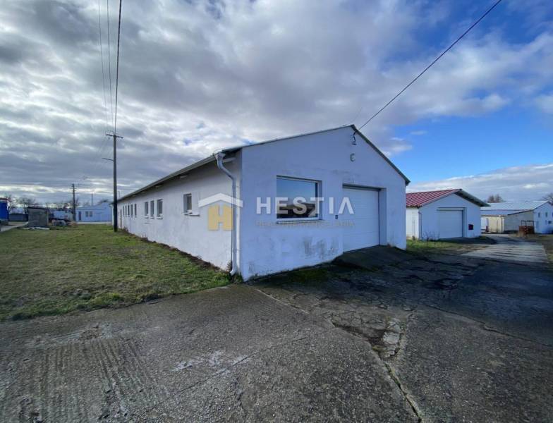 Raktárak és csarnokok Rybkóban füves környezettel felhős ég alatt.