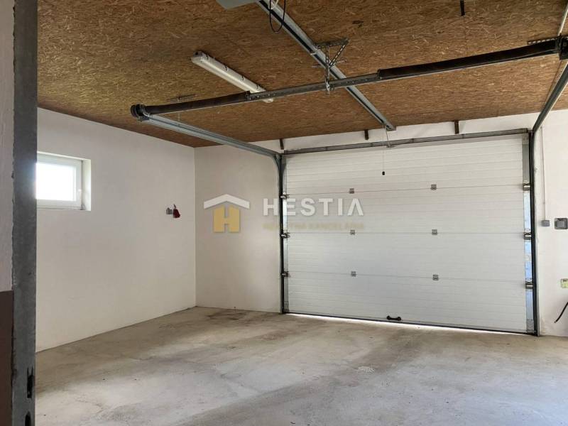 Raktárak és csarnokok belső tere garázskapukkal és betonpadlóval.