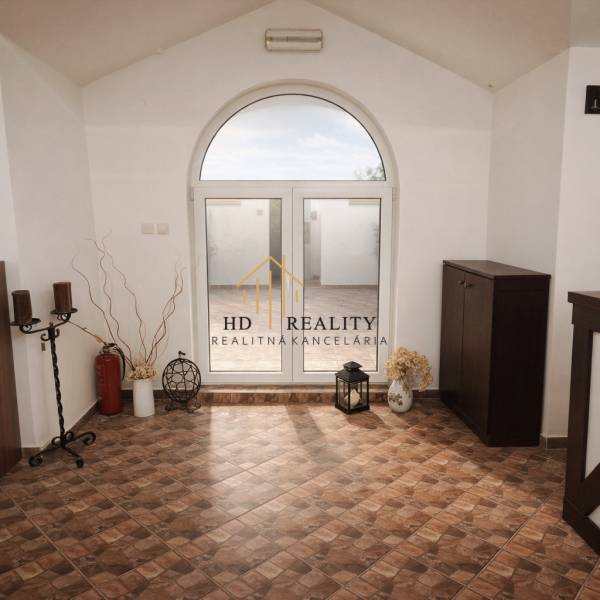 Belső vendéglátóipari terek díszítő elemekkel, csempézett padlóval és nagy íves ablakkal.