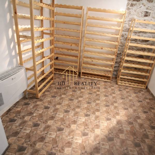 Fa polcok, kőfal, geometriai mintás padló a vendéglátóipari helyiségekben.