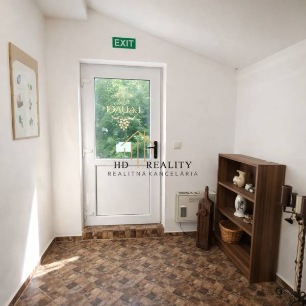 Vendéglátóhely belső terei üvegajtókkal, polccal és fa dekorációjú padlóval.