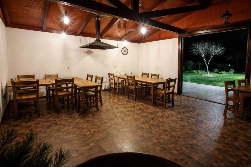 Gasztronómiai terek fa mintázatú padlóval, fa asztalokkal és kilátással a kertre.