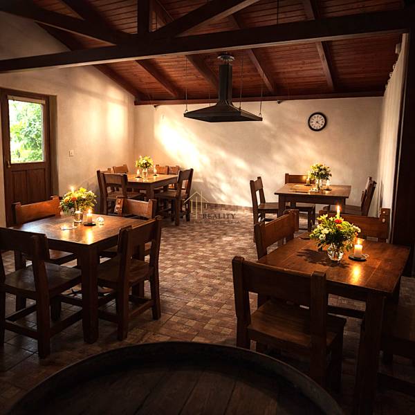 Gasztronómiai terek faasztalokkal és virágokkal, gyertyák a padlón fa dekorációval.