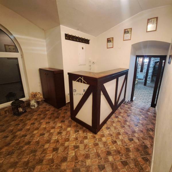 Vendéglátóhely belső tere pulttal, fa dekorációjú padlóval és fogassal.