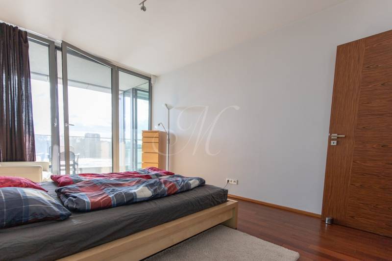 Hálószoba egy kétszobás lakásban fa dekoros padlóval és erkéllyel.