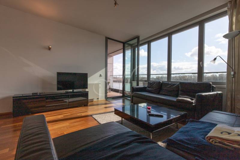 Nappali bőrkanapéval, TV-állvánnyal és fa dekorációjú padlóval, 2 szobás lakás.