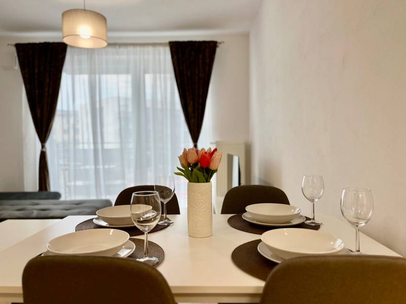 Étkezőasztal egy kétszobás lakásban stílusos dekorációval és virágokkal.