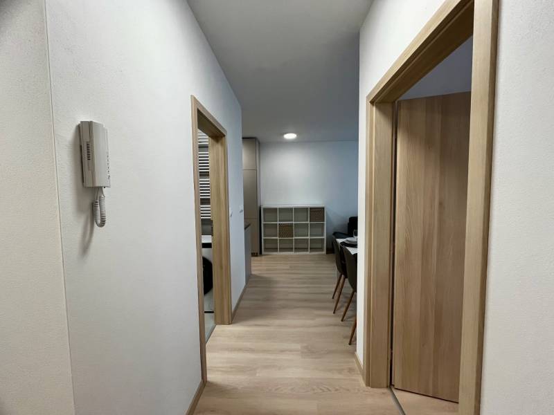 Folyosó egy kétszobás lakásban fa dekorációjú padlóval és egyszerű belső térrel.