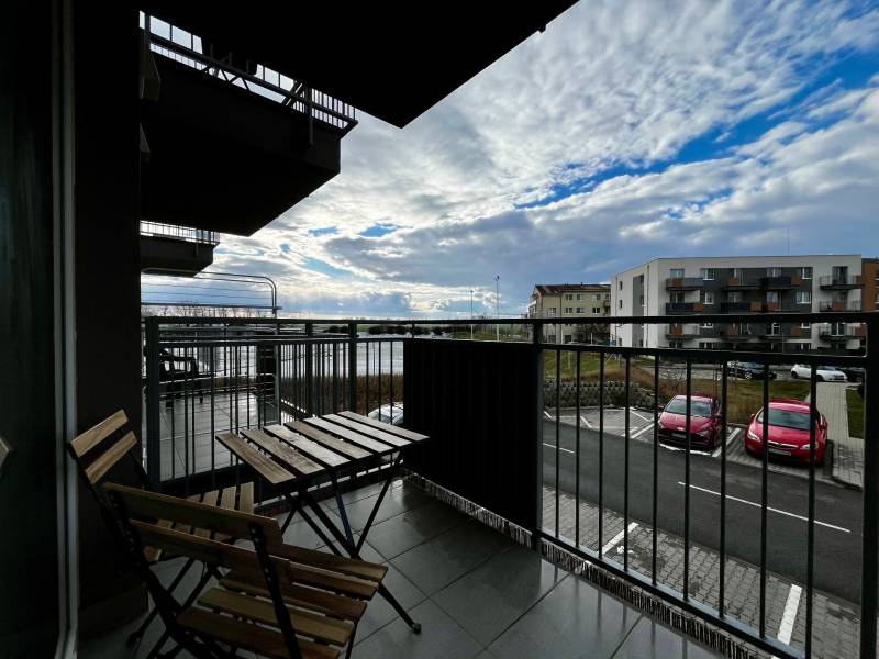 Erkély egy kétszobás lakásban Fehértemplomban, kilátással a parkolóra és az égre.