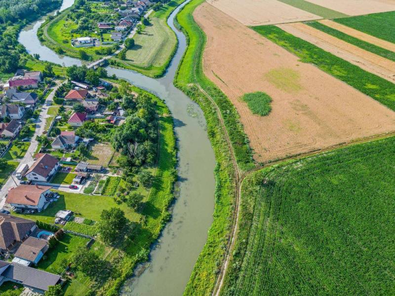 Feketevíz községgel és mezőkkel körülvett folyó mezőgazdasági és erdőterületekkel.